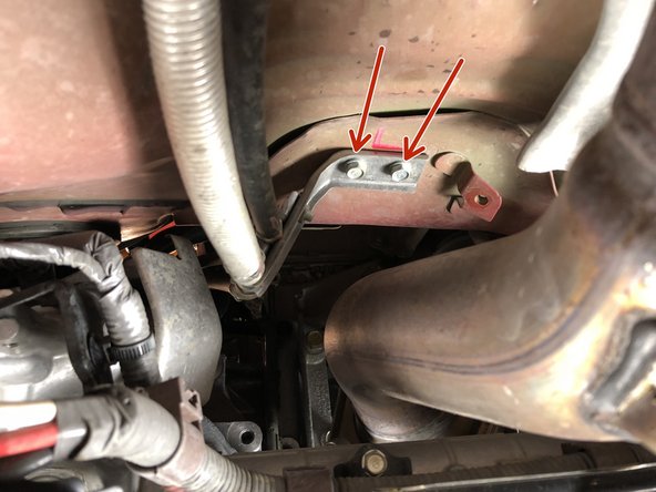 Once the heat shield is out of the way, located the 10mm nuts and bolts holding the shifter cables in place.