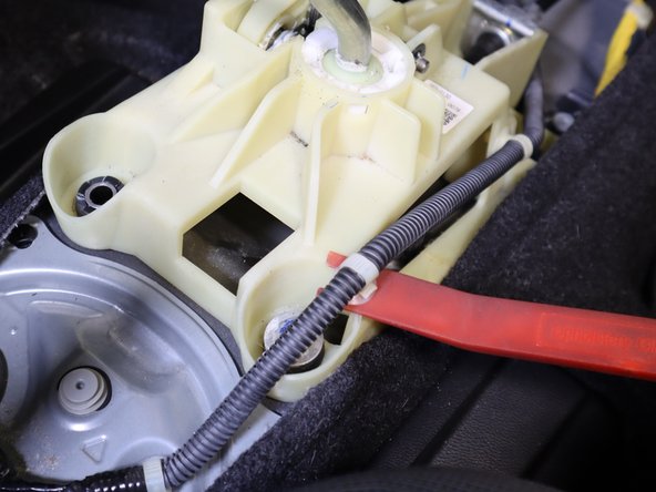 Use a trim tool to remove the clip holding the wiring harness in place. Once the wiring harness is out of the way, remove the Rear Right hand side bolt.