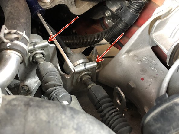 Remove the two shifter cable retaining clips. Use a Flathead screwdriver or pliers and pry them up.