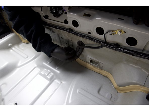 With the grommet free, you will need to fish the other end of the valve harness through the hole. This can be a little tricky but if you have a friend feed the wire, you can pull it through.