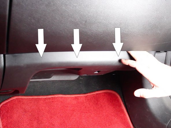 Pull down on the passenger side lower dash panel to expose the center console mounting clips.