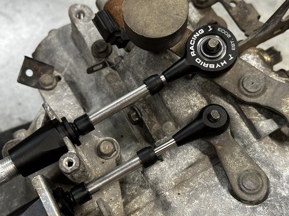 Note the orientation of the shifter cable end link. Make sure the Hybrid Racing logo is facing up and the insert is flat against the gear selector.