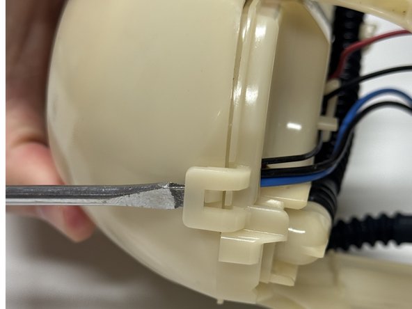 Unclip and open the fuel pump cage.