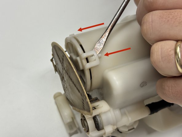 Unclip the lower fuel pump motor cover. Like the case, there are a few clips that surround the lower section.