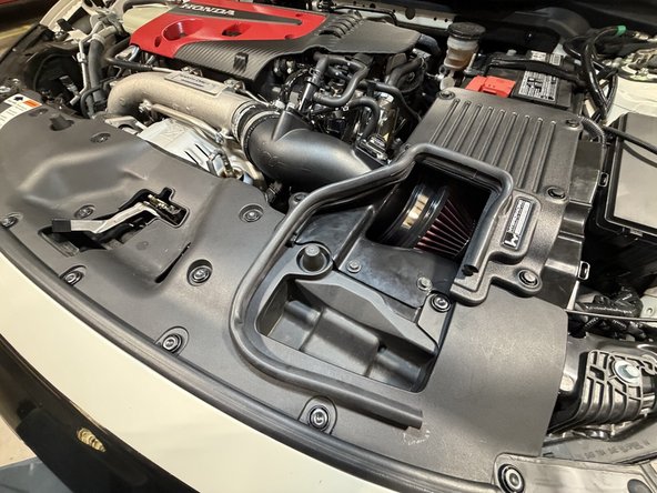 Clean the battery terminal contact faces and reconnect the negative terminal. Check that the clamp heads and breather hoses clear the hood liner before you close the hood.
