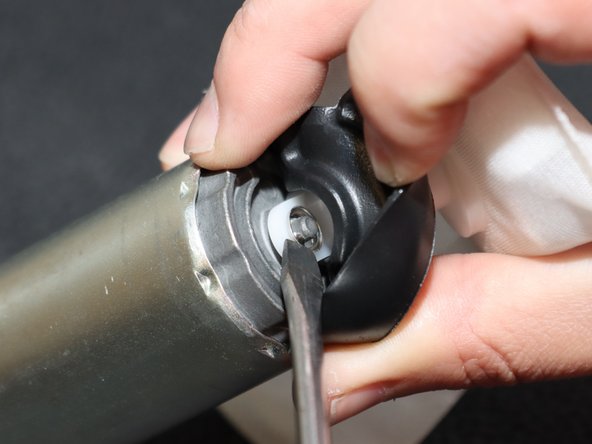 Use a flat-tipped screw driver or pry tool and remove the metal retaining clip holding the pick-up filter in place.