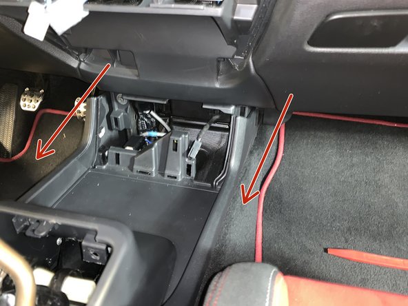Slide the entire console backwards a few inches to unclip it from the dashboard.