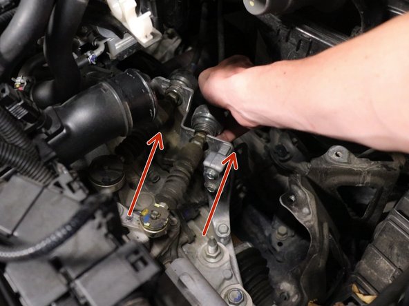 Slide the shifter cable backwards, sliding it out of the bracket. Then, slide it upwards off the gear selector pin.