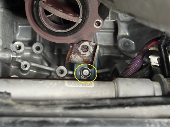 Remove the two 14mm bolts that attach the exhaust manifold to the engine block and remove the support bracket.