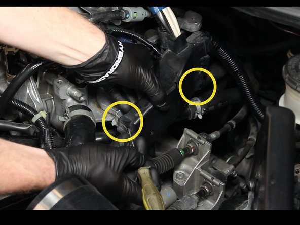 Remove the engine wiring from the bracket. Pull the tabs outward to slide the plastic cover away from the engine.
