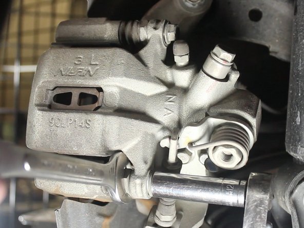 A wrench may be required to hold the inner locking nut on each bolt of the caliper. 