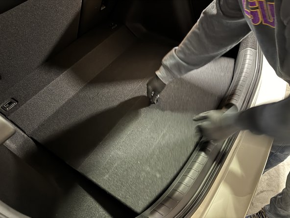 Open the hatch, lift the rear tray and remove the rear well foam panel.