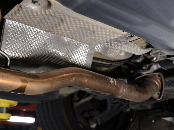 Remove the three bolts holding the exhaust in place. Let it hang down.