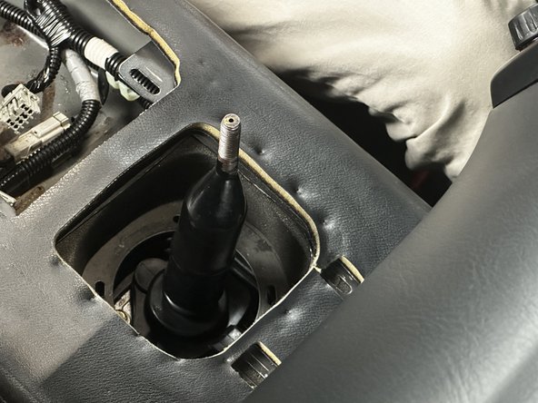 Slide the rubber dust boot cover upwards and remove it from the car. Set this aside, as it will be reinstalled later.