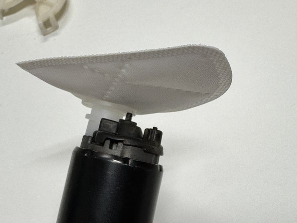 Reinstall the rubber pump isolator and plastic retainer.