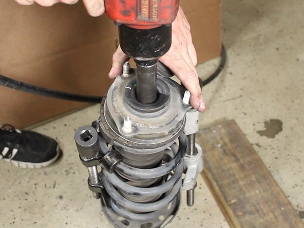 Remove the upper strut mount nut.