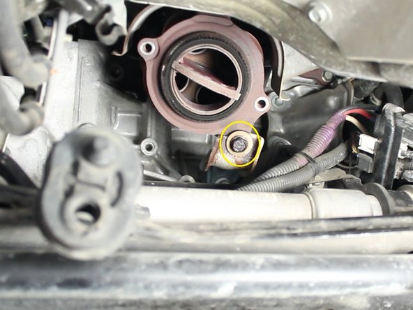 Remove the two 14mm bolts that attach the exhaust manifold to the engine block and remove the support bracket.
