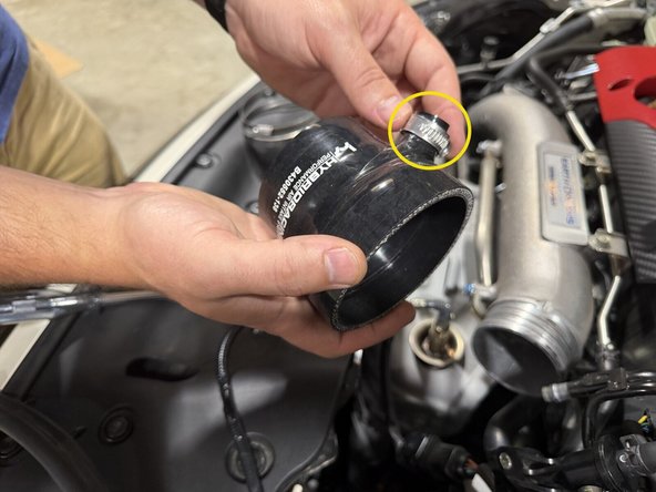 Fit the new coupler onto the turbo inlet and snug the clamp around its beaded edge.