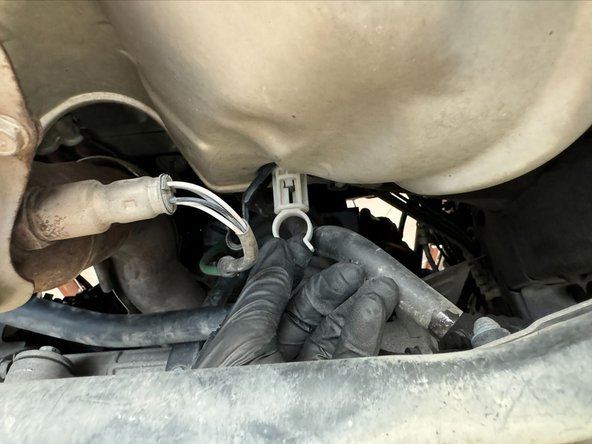 Unscrew the white plastic A/C Condenser stand-off mount. This will expose x1 of the x3 nuts holding Heat-Shield.