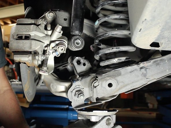 Remove the bolt and slowly lower the jack to separate the lower control arm completely away from the strut.