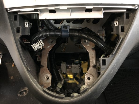 Remove the shifter assembly by pulling the center dash section outwards and upwards. Hold it out of the way to give you more room to pull the shifter out.