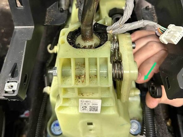 Remove the cotter pin and slide the cable off the stud on the shifter.