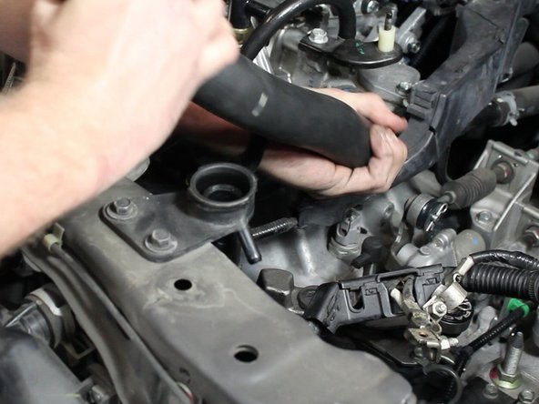 Using a pair of pliers, slide the hose clamps back. Remove the upper radiator hose.
