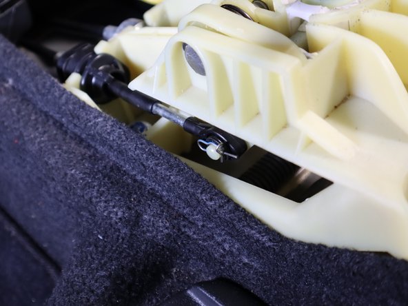 On the left side of the shifter, remove the pin that holds the left hand shifter cable in place. Slide it off the pin.