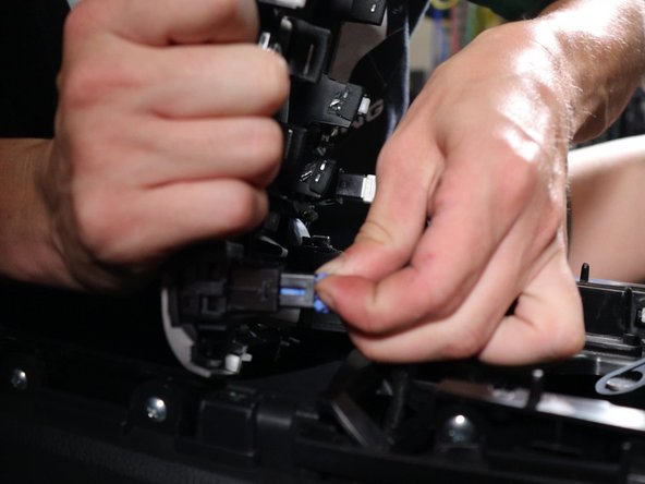 Lift the shift boot cover upwards and unplug all of the electrical connectors.