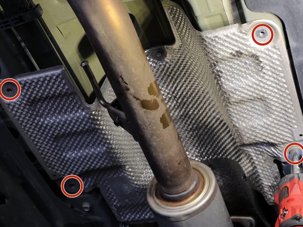 Remove the heat shield bolts and slide it out of the way, exposing the shifter cables.