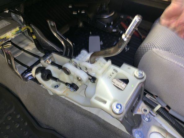 Lift the console from the rear and slide it rearward. Lift it over the shifter and remove it from the car.