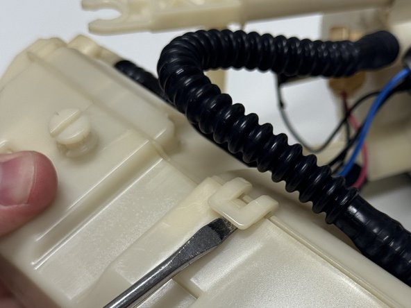 Unclip and open the fuel pump cage.