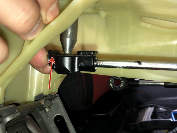 Underneath the shifter, locate the RH side cable end. To remove this from the shifter, you will need to pry the metal spring clip apart. Once the metal clip is off the cable end will slide off the shifter cup.