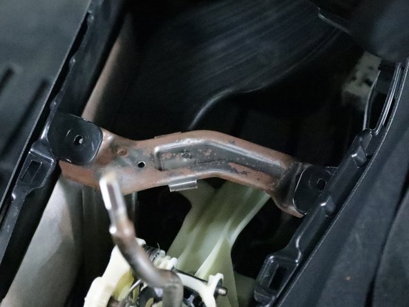 Use a Phillips screwdriver and remove the two screws that hold the console bracket in place.