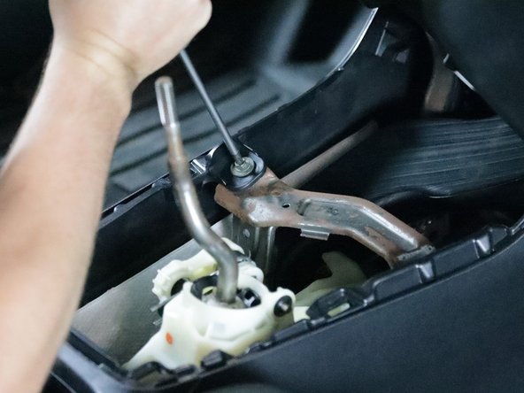 Use a Phillips screwdriver and remove the two screws that hold the console bracket in place.