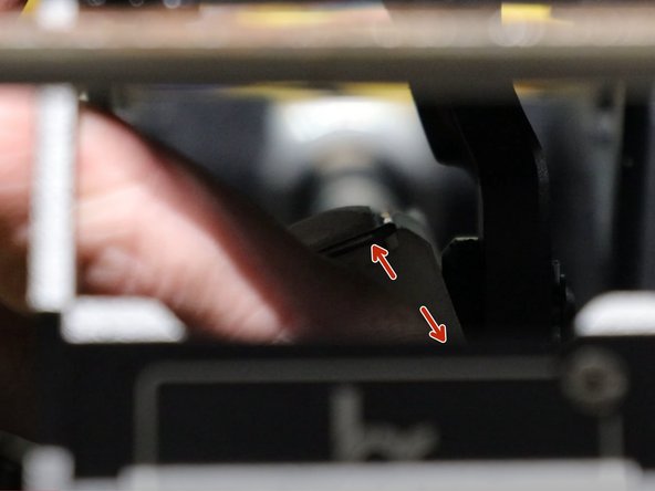 Under the shifter, on the left side shifter cable, use two fingers and spread the metal clip apart.