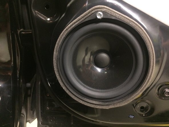 The speaker must be removed in order to remove and install the door stop.