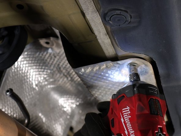 Unbolt and remove the lower heat shield. This will expose the shifter cables.