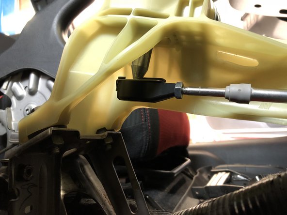 Install the cable end onto the shifter cup. Make sure to snap it in place and be sure the metal retaining clip is secure.