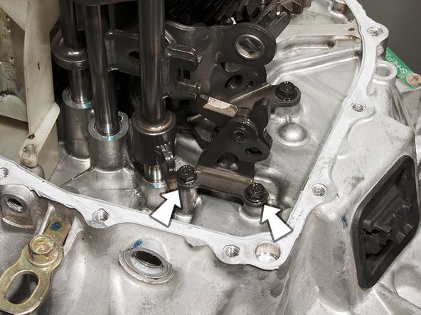 Unbolt and remove the reverse lock-out cam using a 10mm socket. This only applies to the 5 speed model as is shown here. 6 speed models do not have this part.