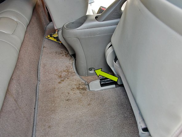 Slide both front seats forward to reveal the final (2) screws holding the center console in. Using the same Phillips head screw driver remove each screw.