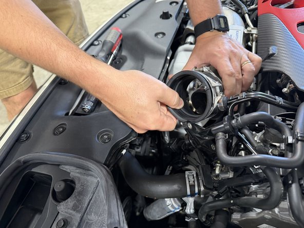 Loosen the coupler clamp at the turbo inlet, pull the coupler off, and remove the smaller hose clamp. Both are circled in the first image.