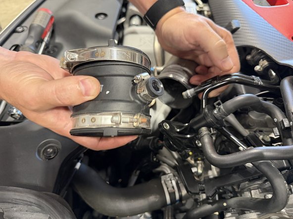 Loosen the coupler clamp at the turbo inlet, pull the coupler off, and remove the smaller hose clamp. Both are circled in the first image.