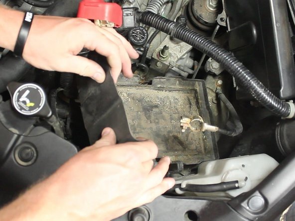 Remove the battery tray cover to expose the battery tray.