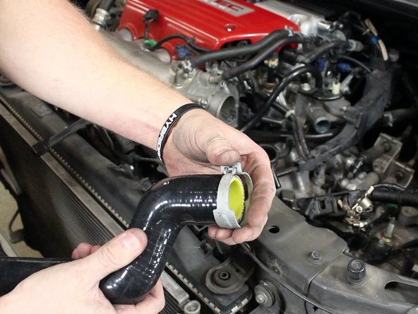 Slide the clamps onto the new upper radiator hose.