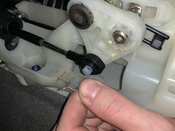 Remove the LH side shifter cable retaining clip.