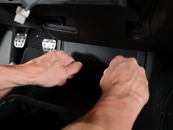 Begin the remove the lower section of the console by pulling the console panel outward. This contains the 12v socket and USB ports.