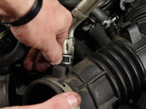 Unclamp and remove the valve cover vent tube from the intake tube.