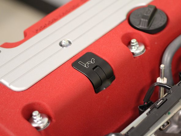 Push the dipstick into the engine and swing the latch down, locking it into place. The dipstick should sit flush with the valve cover.