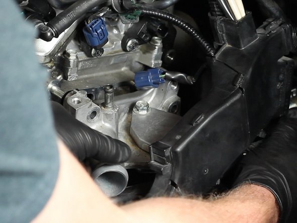 Slide the coolant housing away from the engine and remove it from the engine bay.